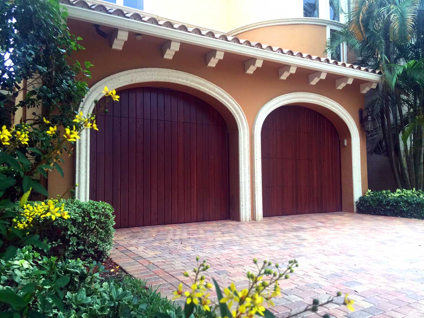 Faux mahogany finish on Spanish-style arched garage doors