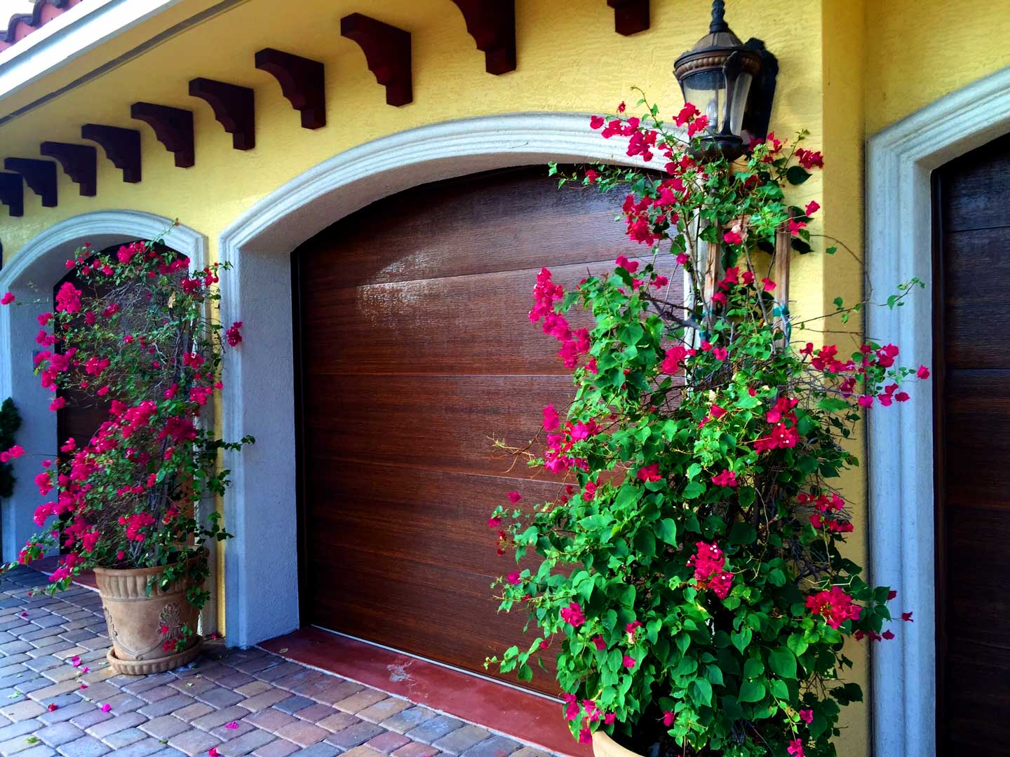Faux walnut finish on arched garage door with bougainvillea
